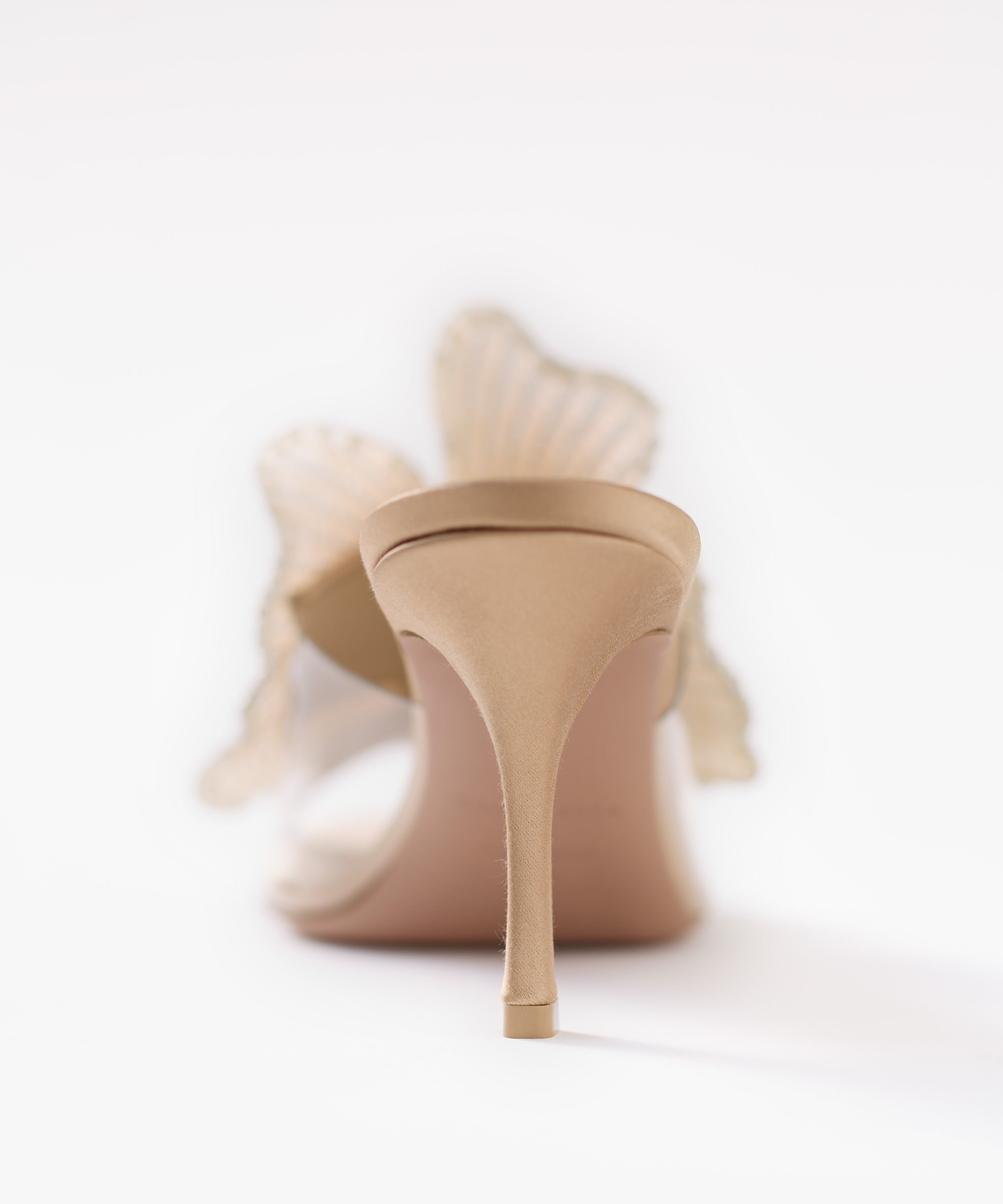 Beige satin high-heeled shoes on a white background