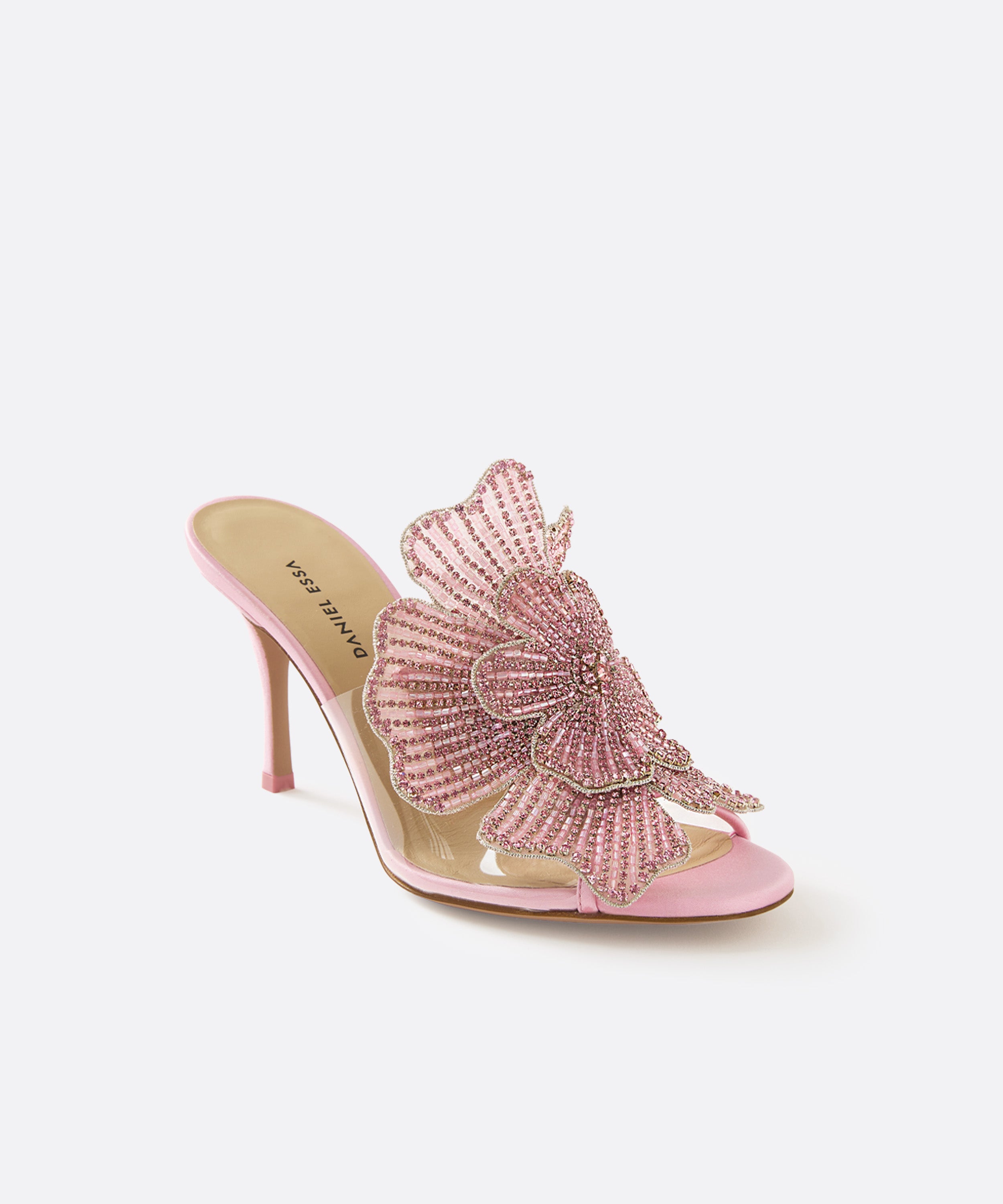 Pink high-heeled shoe with a sparkling flower on a white background