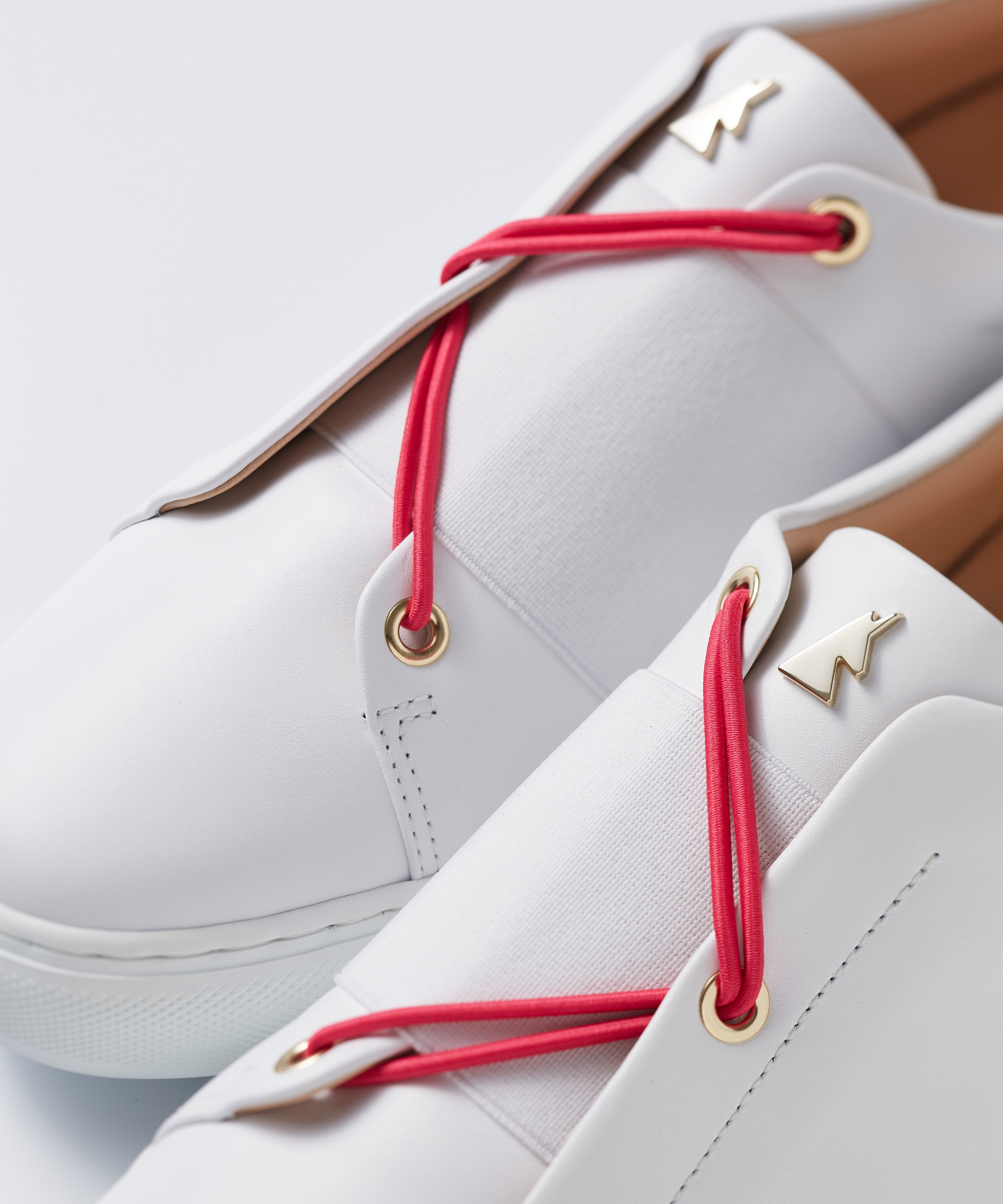 Close-up view of interchangeable pink fushia elastic laces for Toi&Moi sneakers, shown on a white premium leather pair